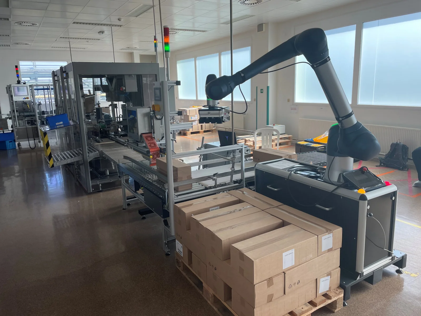Robotické paletizační pracoviště s dopravníky a kartony na paletě